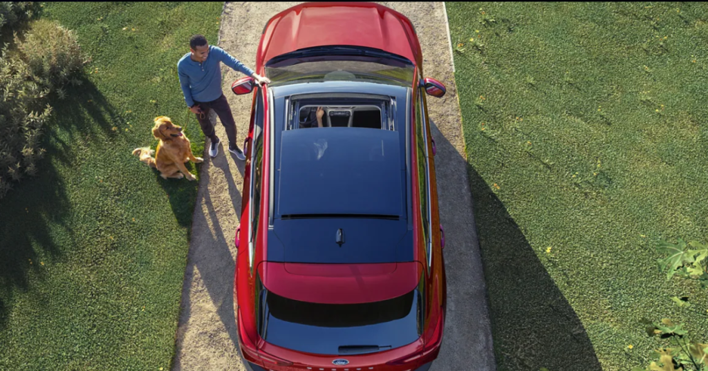 A new red 2023 Ford Escape sits in the driveway with its moonroof shown open.