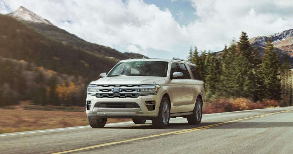 Ford Expedition driving down a road in the mountains.