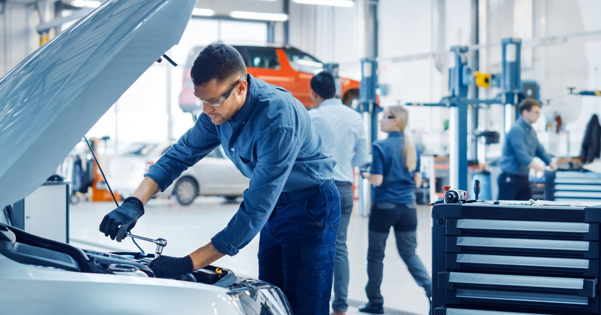 Ford service technicians performing maintenance on vehicles in a Ford service center.