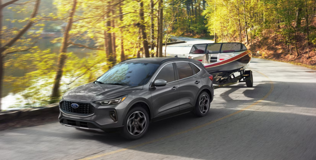 The 2026 Ford Escape travels down a road towing a boat behind it. Shop for your new 2026 Ford Escape at Johnson City Ford near Kingsport.