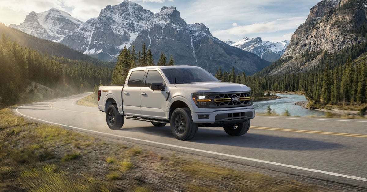 The Ford F-150 travels on a mountainous road.